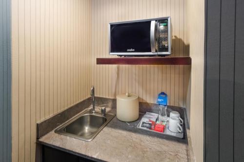 萨尔蒂约喜来登萨尔蒂福朋酒店的厨房柜台设有水槽和微波炉