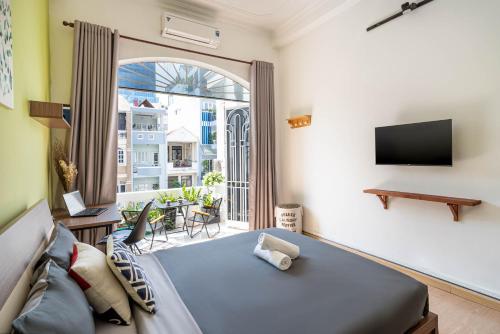 胡志明市西贡霍罗通话度假屋 - 服务式民宿的一间卧室设有一张床和一个大窗户