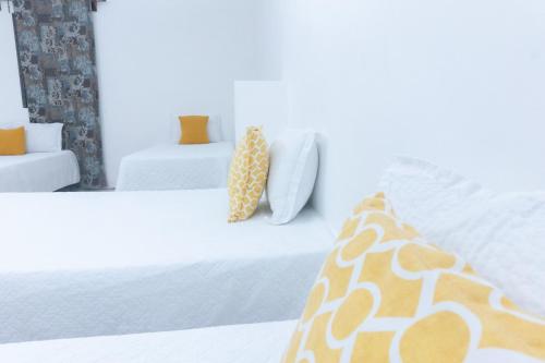 拉利伯塔德Hotel Tunco Lodge的一间卧室配有两张带白色床单和橙色枕头的床。