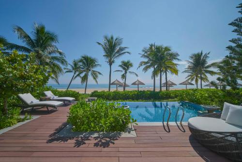 岘港Danang Marriott Resort & Spa, Non Nuoc Beach Villas的一个带游泳池和棕榈树的度假村