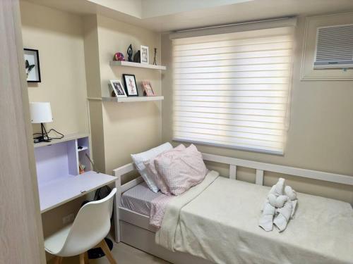 伊洛伊洛Stay comfy & feel Homealike #32的一间小卧室,配有一张床、一张书桌和一个窗户