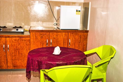 NausoriGuddy’s Riverside Cottage的厨房配有桌子和两把绿色椅子