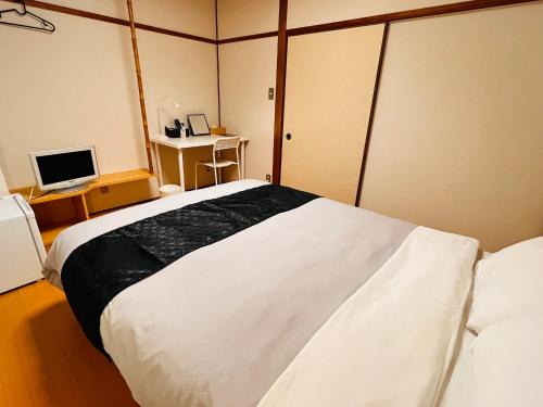 壹岐市IKI Island HUB的卧室配有一张白色大床和一张书桌