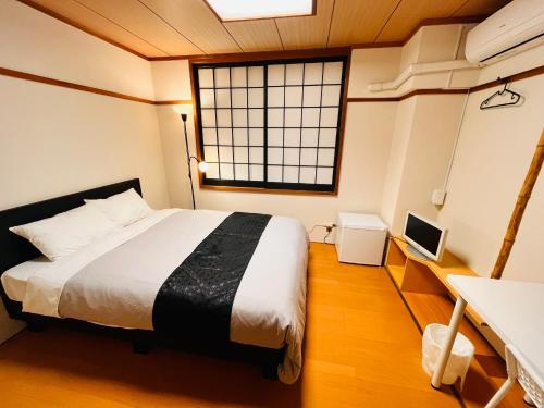 壹岐市IKI Island HUB的一间卧室设有一张大床和一个窗户。