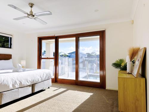 黄金海岸Waterfront Haven Balinese Villa at Bundall的一间卧室设有一张床和一个滑动玻璃门