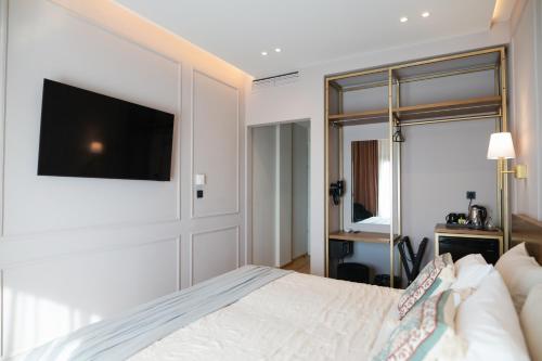 亚历山德鲁波利斯阿格洛斯酒店的卧室配有一张床,墙上配有电视。