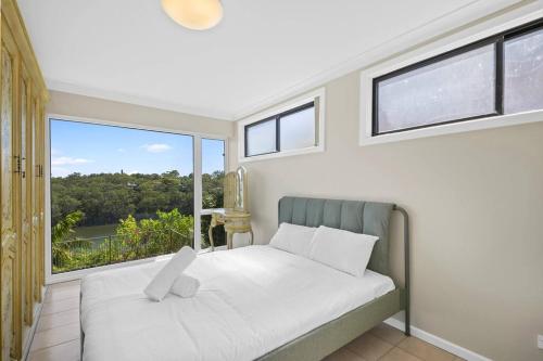 悉尼River View Oasis: Spacious 3-Bed House with Pool的一间卧室设有一张床和一个大窗户