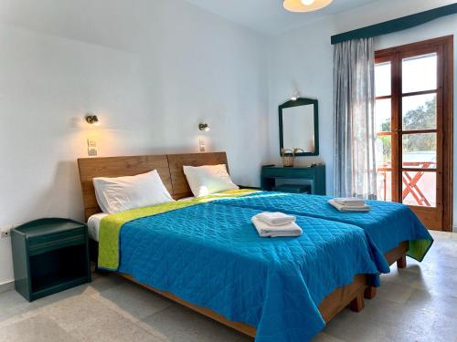 布拉卡Nostos Plaka Beach的一间卧室配有蓝色的床和毛巾