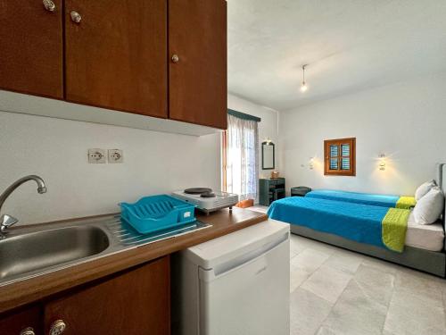 布拉卡Nostos Plaka Beach的一个带水槽的厨房和一张位于客房内的床