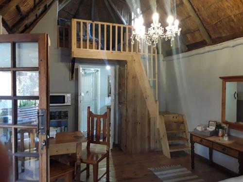 布隆方丹Oudam Overnight Accomodation的客房设有楼梯、桌子和吊灯。
