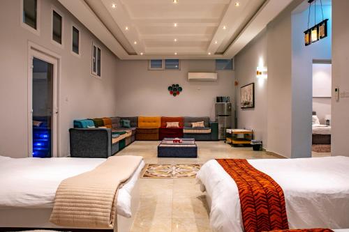 Umm al ‘AmadElegant Garden & 2Living Areas, 2 Bed Rooms for 6 Guests的一间带两张床和一张沙发的客厅