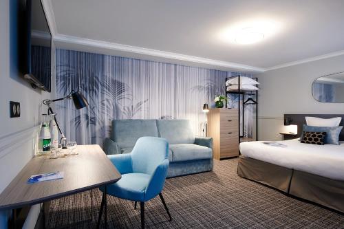 巴黎Hotel Vacances Bleues Provinces Opera的酒店客房,配有一张床和一张蓝色椅子