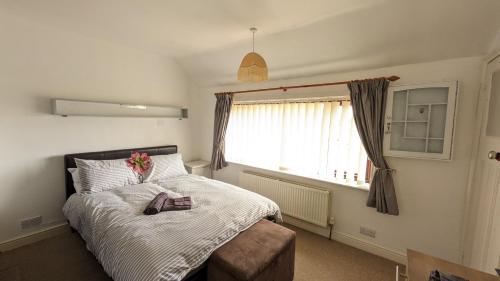 诺里奇Relaxing 3 Bedroom Norwich Haven的一间卧室,配有一张带鲜花的床