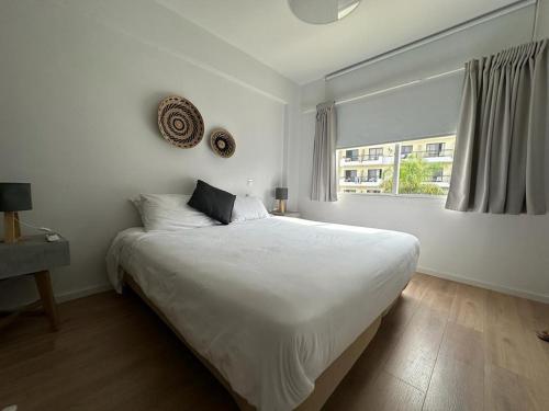 普罗塔拉斯KSQUARED的白色的卧室设有一张大床和一个窗户
