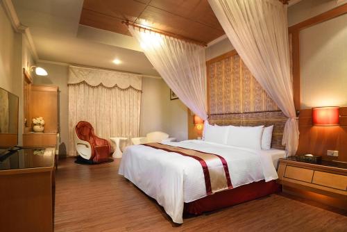 台南纳多利汽车旅馆 的一间卧室配有一张大床和一把椅子