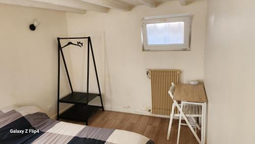 马恩河畔讷伊CHAMBRE dans une maison partagée的一间卧室设有一张床、一个窗口和梯子