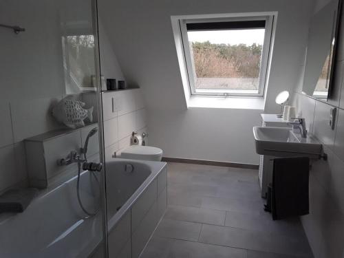 东贝沃恩Pleasant apartment in Ostbevern的一间带两个盥洗盆、卫生间和窗户的浴室