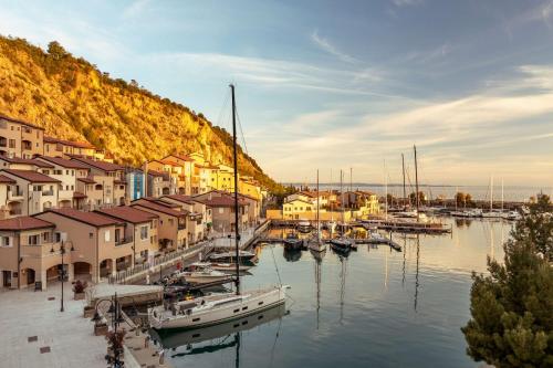 西斯蒂亚纳Tivoli Portopiccolo Sistiana Wellness Resort & Spa的一群船停靠在码头,有建筑物