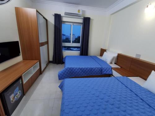 格卢市社Sóng Biển Hotel Cửa Lò的酒店客房设有两张床和一台平面电视。