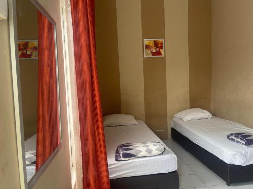 北干巴鲁OYO 93850 Njy House Syariah的小型客房的两张床,配有镜子