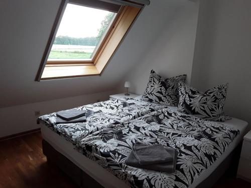 东贝沃恩Holiday apartment Aufderhaar的一张带黑白色棉被的床和窗户