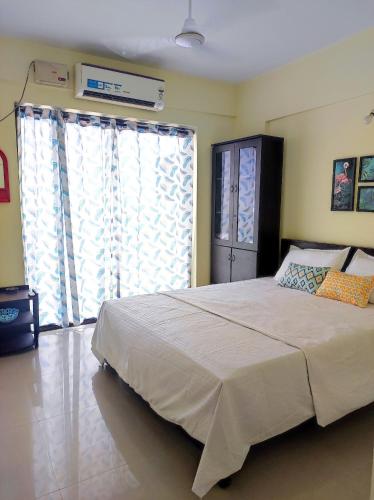 科钦1 BHK Flat in Kochi 904的一间卧室设有一张大床和一个大窗户