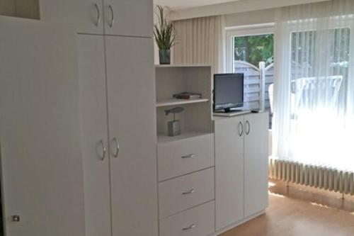 韦斯特兰Apartment in Westerland的客厅配有白色橱柜和电视