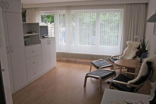 韦斯特兰Apartment in Westerland的一间带桌子和两把椅子的客厅和一间带桌面的房间