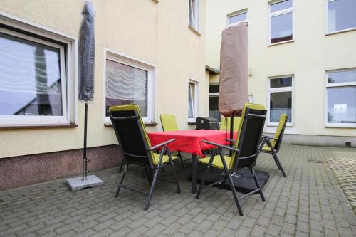 马尔肖Apartment in Malchow with terrace的一张桌子和椅子,配有红色的桌子和窗户