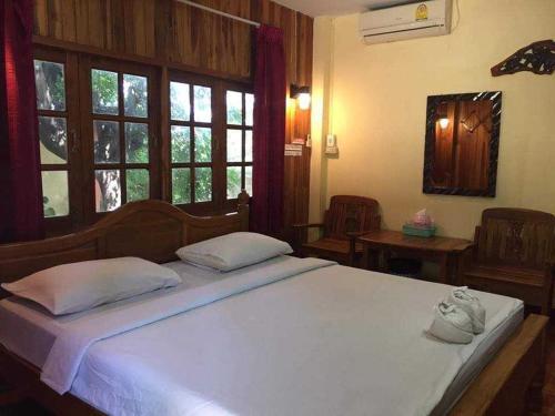 Ban Mae Laiบ้านสวนกุหลาบแก้วรีสอร์ท的卧室设有一张带窗户的白色大床