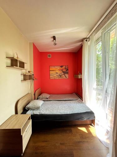 克拉科夫Cosy room Aleja Kijowska的一间卧室配有一张红色墙壁的床