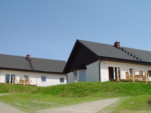 赛巴特班森Cottage Heringsdorf的两座白色建筑,屋顶黑色