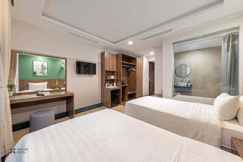 河内Nature Hanoi Hotel的酒店客房配有两张床和一张书桌
