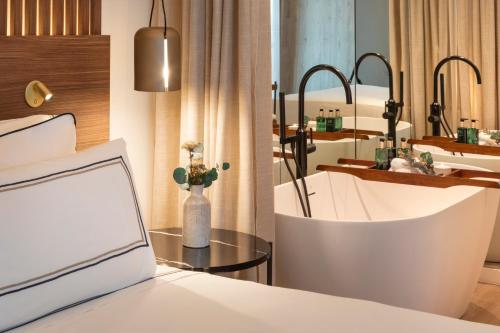 格拉纳达格拉纳达美利亚酒店的一间卧室配有一张床和一张带笔记本电脑的桌子
