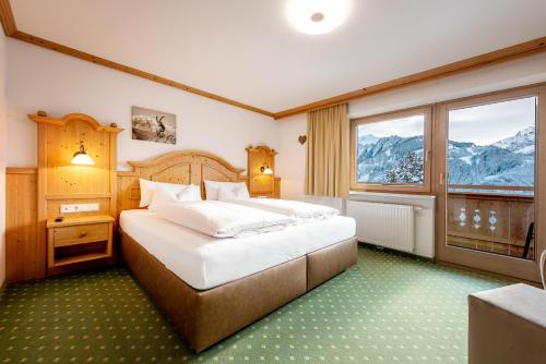 弗林肯贝格Astegg, Alpengasthof的一间卧室设有一张大床和一个大窗户