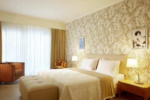 阿菲托斯阿菲提斯精品酒店的一间卧室配有一张大床和一把椅子