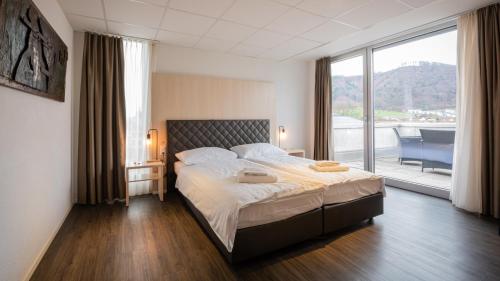 贝尔普Los Lorentes Hotel Bern Airport的一间卧室设有一张大床和一个大窗户