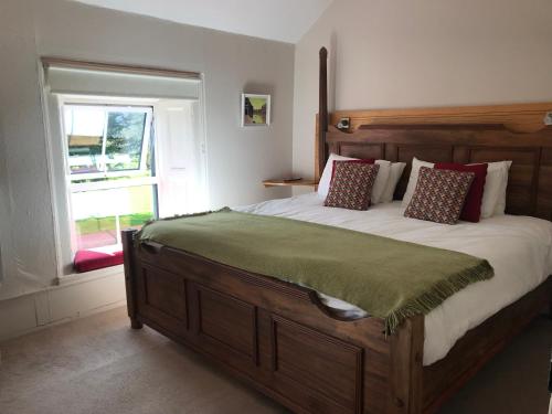 肯梅尔Gortamullen House, Kenmare的一间卧室设有一张大木床和窗户