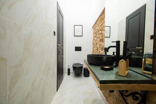 科洛皮奥Stoa House Airport的浴室设有黑色水槽和镜子