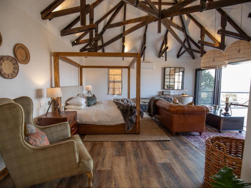 奥奇瓦龙戈Otjiwa Mountain Lodge的一间卧室配有一张大床和一张沙发