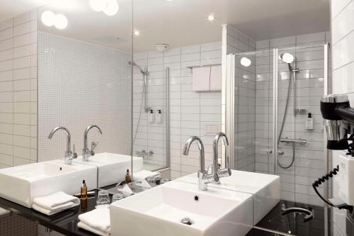斯德哥尔摩斯堪迪克维多利亚大厦酒店的一间带两个盥洗盆和淋浴的浴室