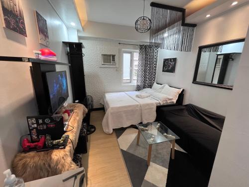 马尼拉Me N’ My Bed Staycation @ SMDC Trees Residences的客房设有两张床、一张沙发和一台电视。