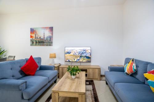 迪拜RH- Experience Comfort and Convenience in our 2BR, Al Barsha的客厅配有蓝色的沙发和咖啡桌