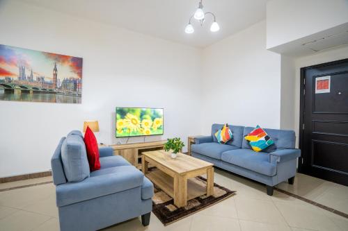 迪拜RH- Experience Comfort and Convenience in our 2BR, Al Barsha的客厅配有2张蓝色的沙发和1张桌子