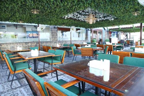 沙迦Zenith Smart Vacation Homes, Sharjah的餐厅设有桌椅,天花板上常春藤
