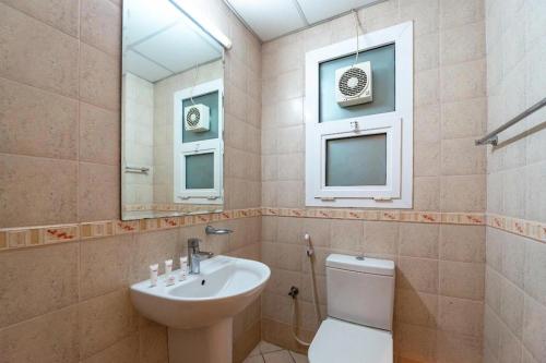 沙迦Zenith Smart Vacation Homes, Sharjah的一间带水槽、卫生间和镜子的浴室
