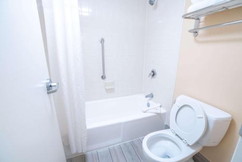 西棕榈滩Quality Inn Palm Beach International Airport的白色的浴室设有卫生间和浴缸。