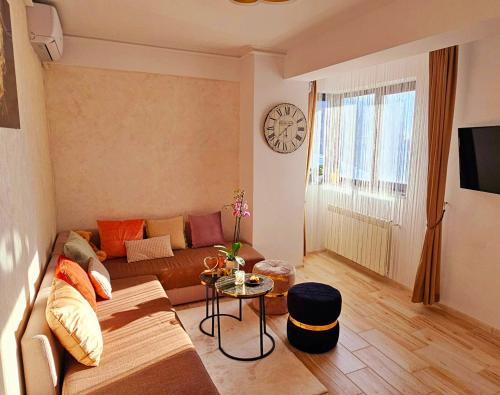 马马亚Iaki Apartment Mamaia的客厅配有沙发和墙上的时钟