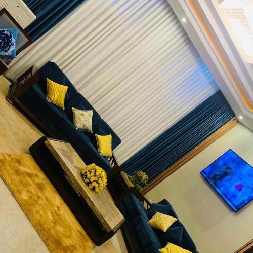 麦可乐ZEMARIAS INTERNATIONAL HOTEL的客厅配有蓝色沙发及黄色枕头