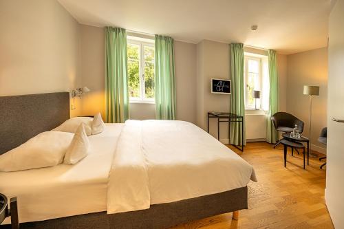 阿伦斯霍普Der Charlottenhof的卧室配有带绿色窗帘的大型白色床